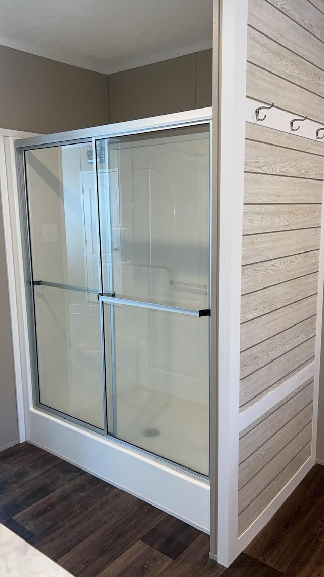 full bathroom with a shower with door and wood finished floors