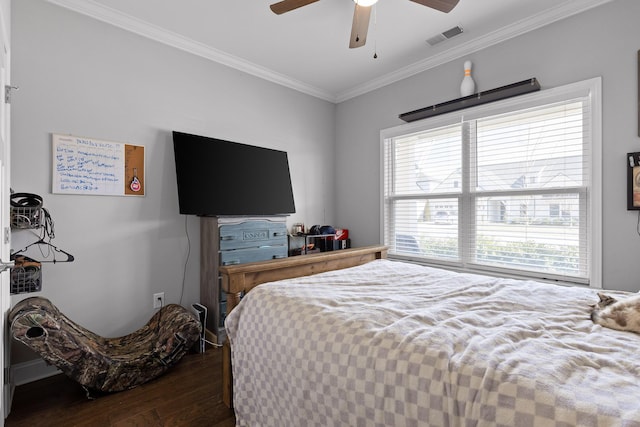 bedroom featuring a ceiling fan, visible vents, wood finished floors, and ornamental molding