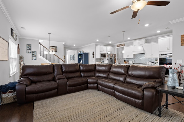 living area with light wood-style flooring, visible vents, stairway, and crown molding