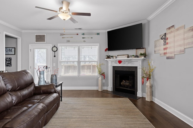 living room with a fireplace with flush hearth, wood finished floors, visible vents, and crown molding