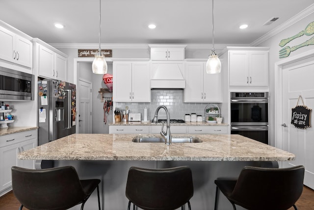 kitchen with white cabinetry, custom range hood, appliances with stainless steel finishes, tasteful backsplash, and crown molding