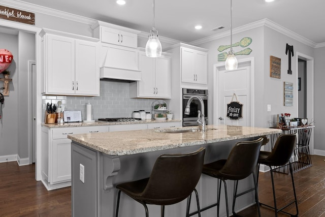 kitchen featuring crown molding, an island with sink, dark wood-style floors, and custom range hood