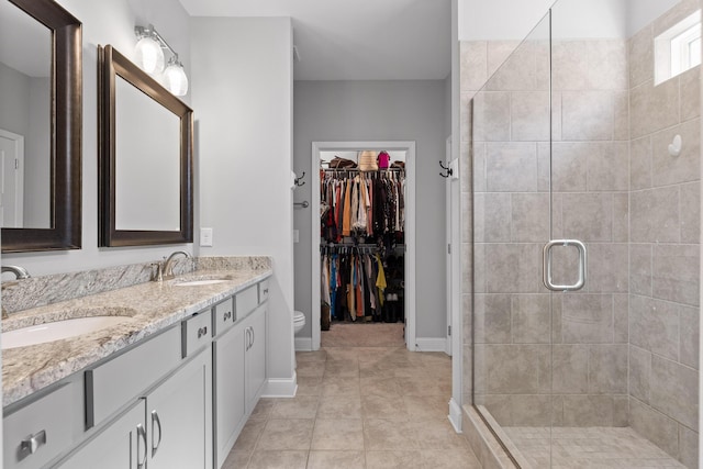 bathroom with double vanity, tile patterned floors, a sink, and a shower stall