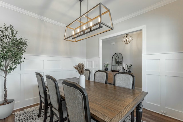 dining room with ornamental molding, a decorative wall, and dark wood-style floors