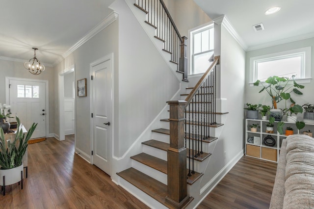 staircase featuring visible vents, crown molding, baseboards, and wood finished floors