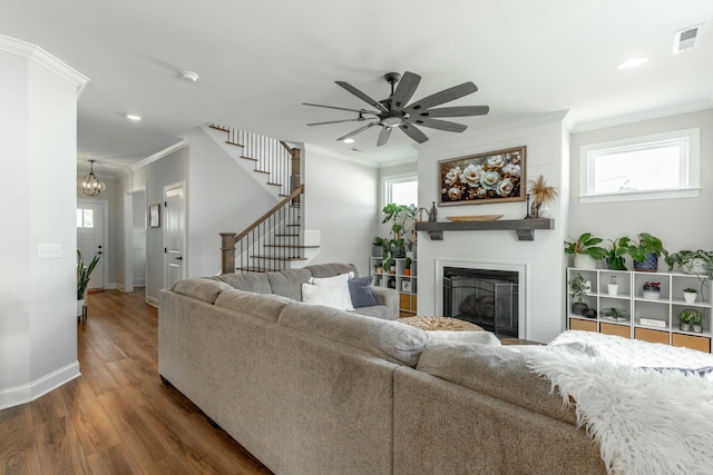 living area featuring ornamental molding, dark wood-type flooring, plenty of natural light, and visible vents