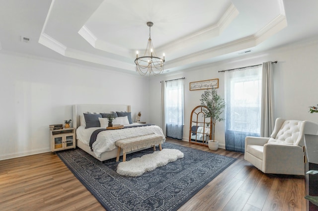 bedroom featuring a tray ceiling, dark wood finished floors, visible vents, and a notable chandelier