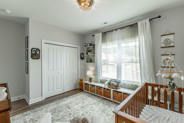 bedroom featuring a closet, wood finished floors, visible vents, and baseboards