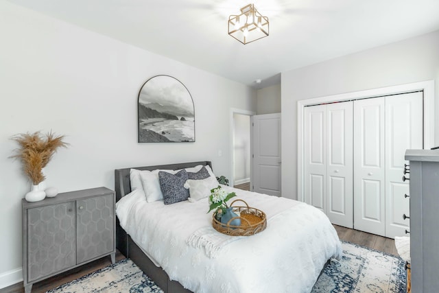 bedroom featuring dark wood-type flooring, a closet, and baseboards