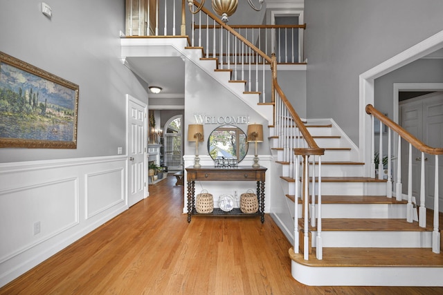 foyer with stairs, a high ceiling, and wood finished floors