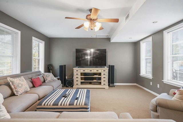 carpeted living area featuring a ceiling fan, visible vents, and baseboards