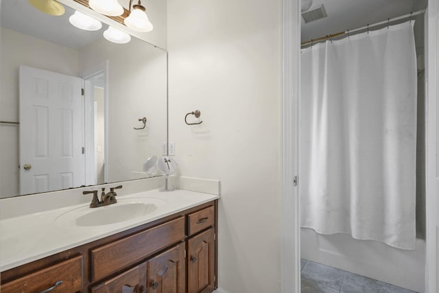 full bath featuring tile patterned flooring, a notable chandelier, a shower with shower curtain, visible vents, and vanity