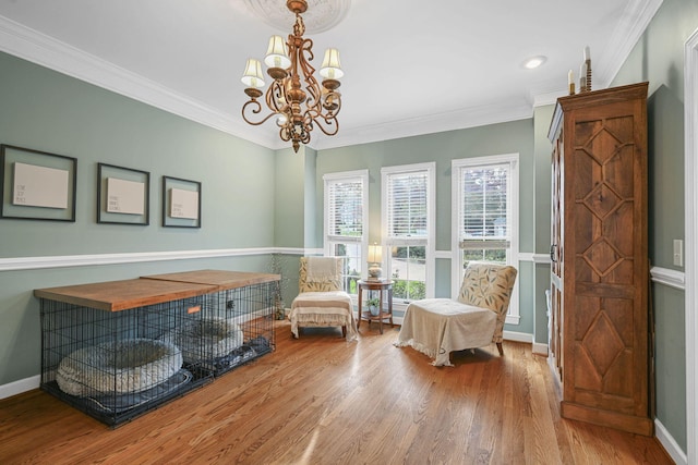 sitting room with crown molding, baseboards, and wood finished floors