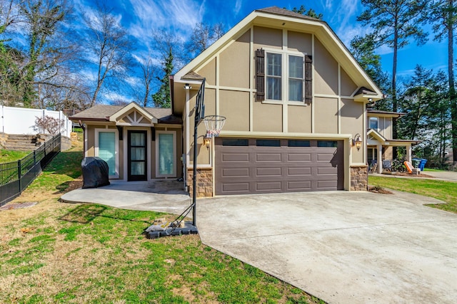 view of front facade featuring a garage, fence, driveway, and stucco siding