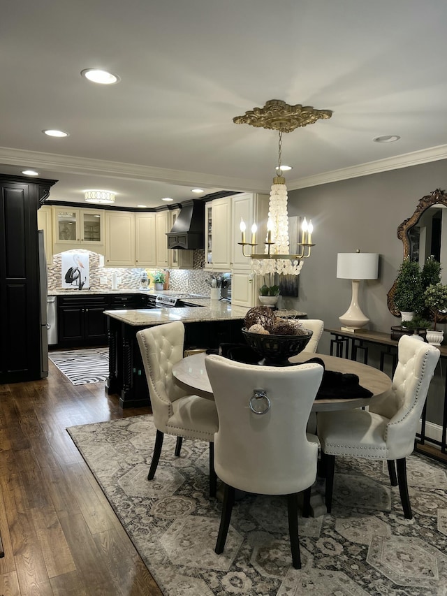 dining space with a chandelier, recessed lighting, dark wood-style flooring, and crown molding