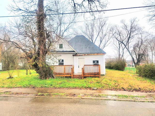 rear view of property with a deck and a lawn