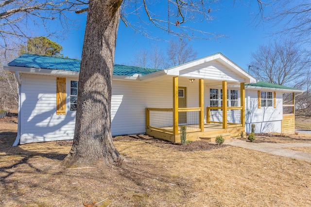 view of front of home featuring metal roof and a porch