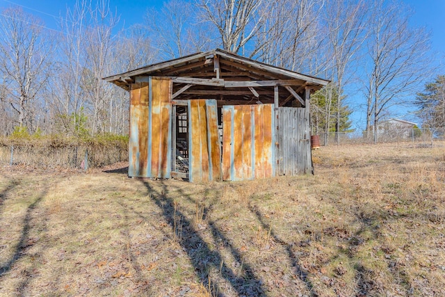 view of outbuilding featuring fence and an outbuilding