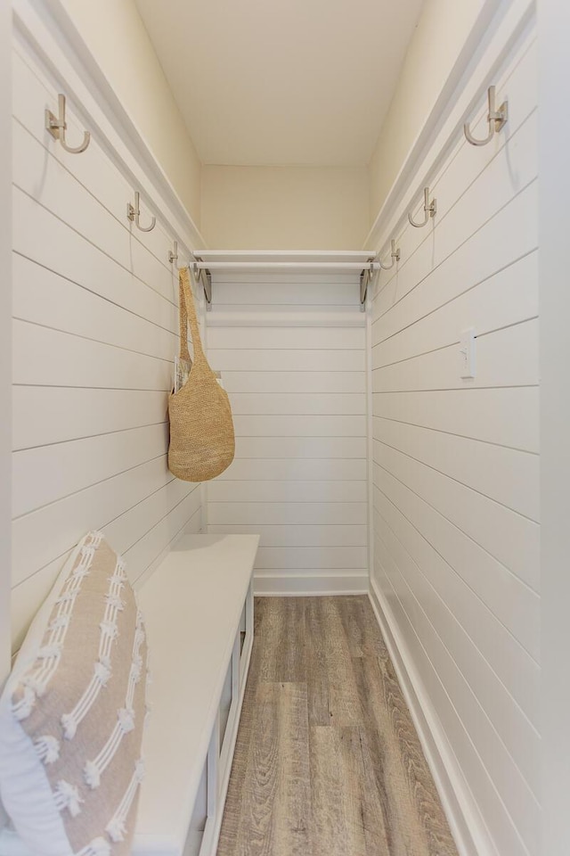 mudroom featuring wood walls and wood finished floors