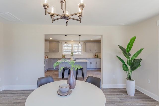 dining area featuring recessed lighting, an inviting chandelier, light wood-style flooring, and baseboards