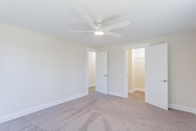 unfurnished bedroom with light colored carpet, ceiling fan, and baseboards