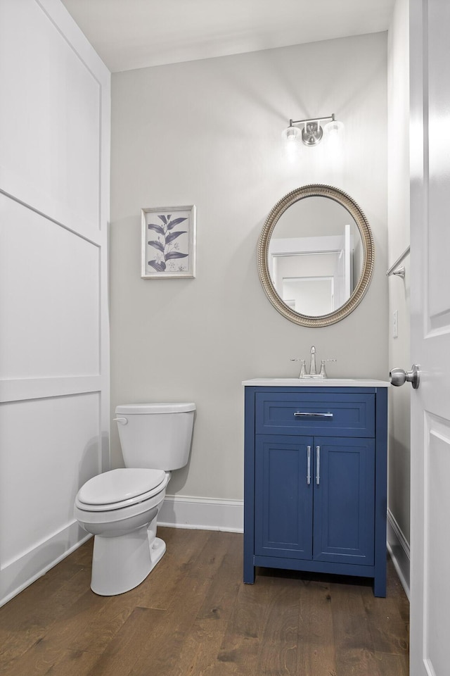 bathroom featuring wood-type flooring, vanity, and toilet