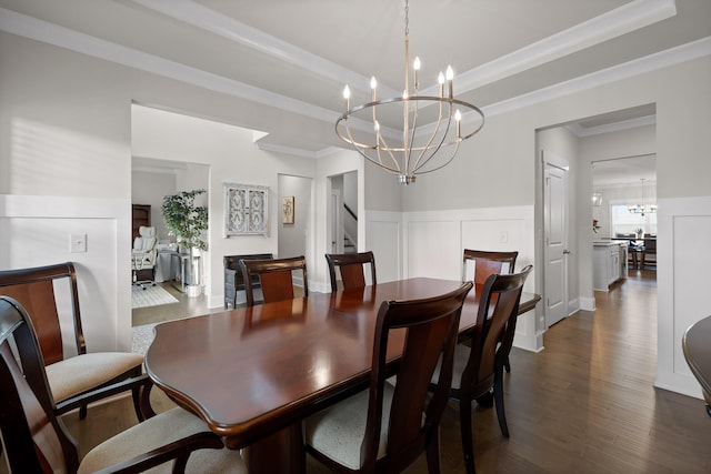 dining room with crown molding, a chandelier, a tray ceiling, and dark wood-type flooring