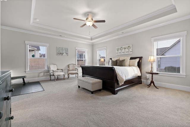 carpeted bedroom with a raised ceiling, crown molding, and multiple windows