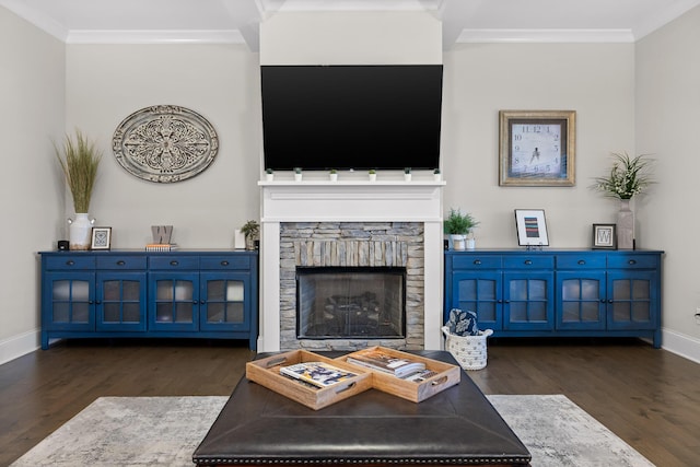 living room featuring dark hardwood / wood-style flooring, a stone fireplace, and crown molding