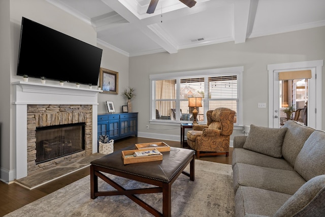 living room with ornamental molding, beam ceiling, a stone fireplace, dark hardwood / wood-style flooring, and coffered ceiling