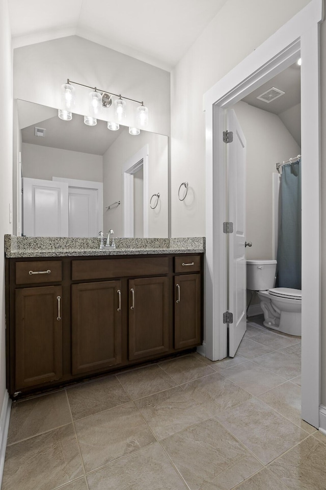 bathroom featuring lofted ceiling, vanity, and toilet