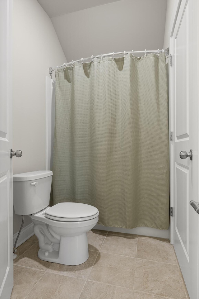 bathroom featuring tile patterned floors, walk in shower, and toilet