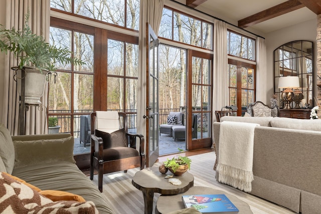 sunroom / solarium featuring french doors, beamed ceiling, and a wealth of natural light