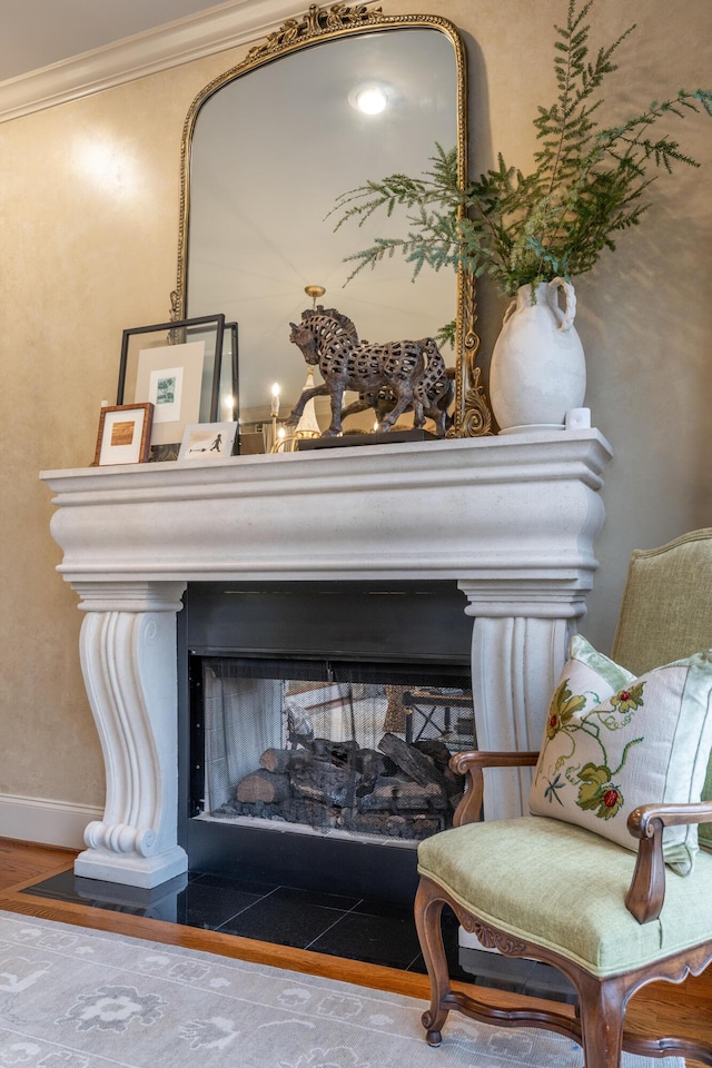 room details with ornamental molding, a multi sided fireplace, baseboards, and wood finished floors