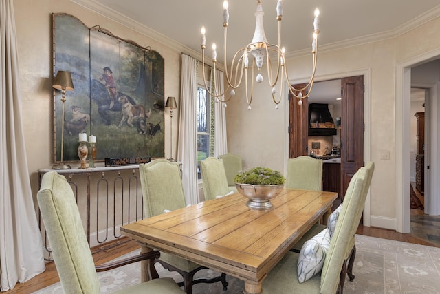 dining space featuring ornamental molding, light wood finished floors, and a notable chandelier