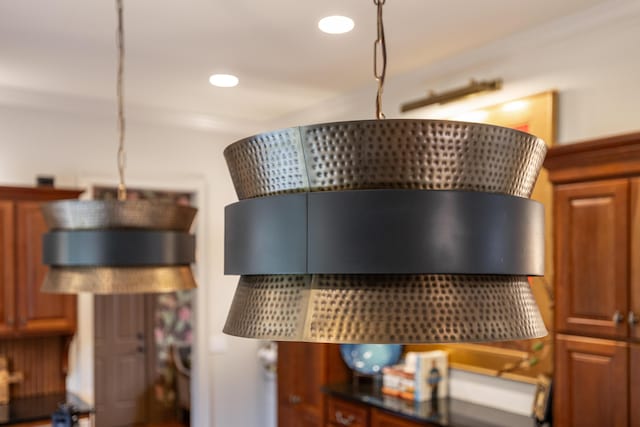 details featuring recessed lighting, dark countertops, decorative light fixtures, and brown cabinets