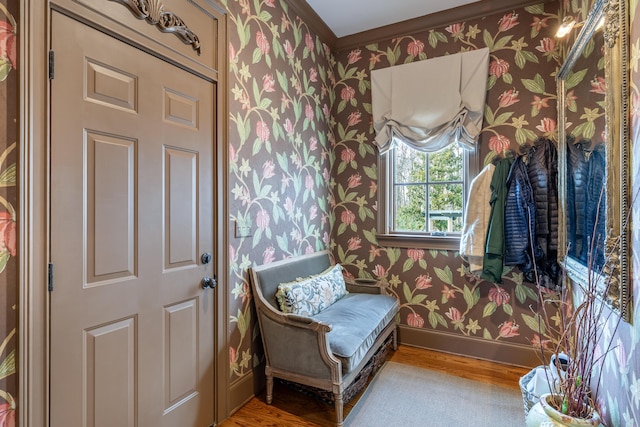 sitting room with wallpapered walls, baseboards, and wood finished floors