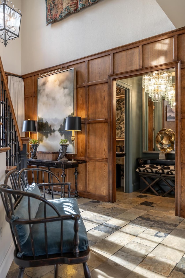 interior space featuring a chandelier, stone tile flooring, a high ceiling, and stairs