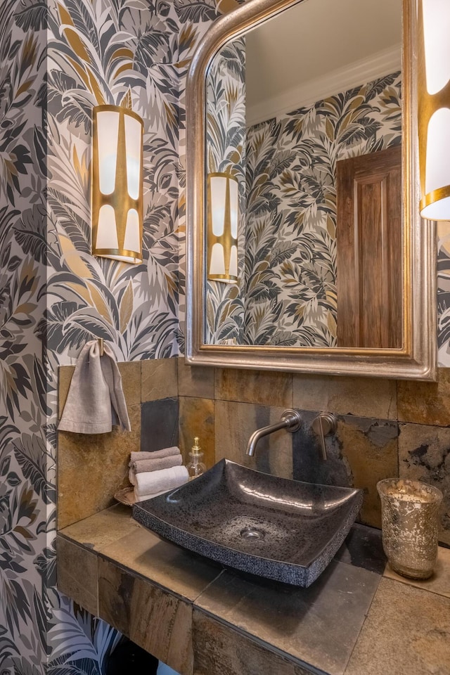 bathroom with wallpapered walls and a sink