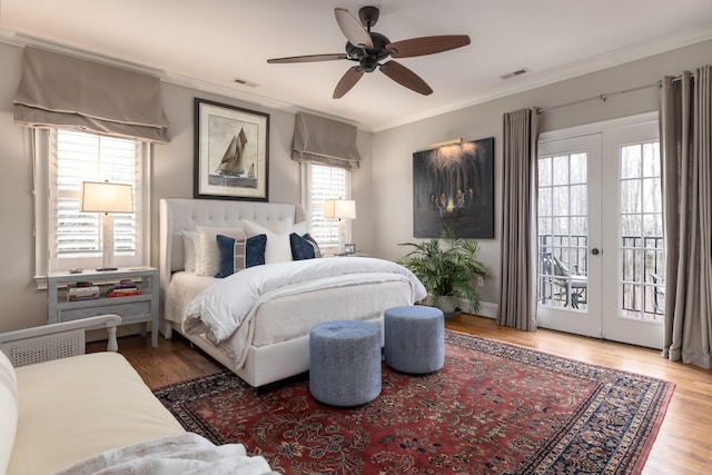 bedroom with wood finished floors, visible vents, access to exterior, french doors, and ornamental molding