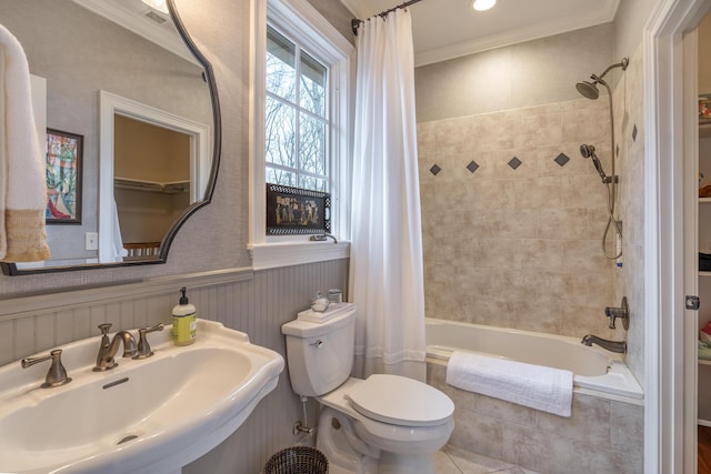 full bath featuring tiled shower / bath, wainscoting, a sink, and crown molding