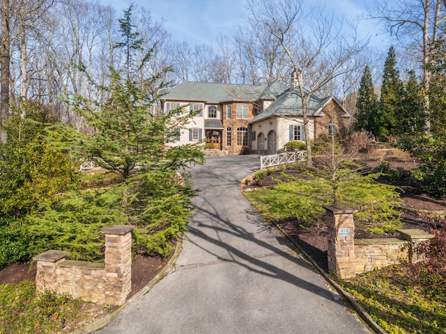 view of front facade with driveway and stone siding