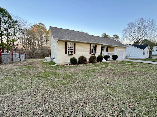 view of front facade with a garage, a front lawn, a shingled roof, and fence