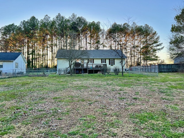 rear view of house with a fenced backyard, a lawn, and a wooden deck