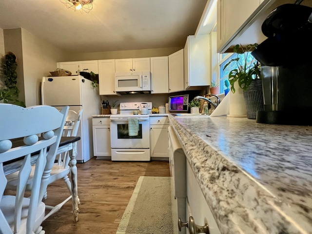 kitchen with white appliances, dark wood-type flooring, a sink, and white cabinetry