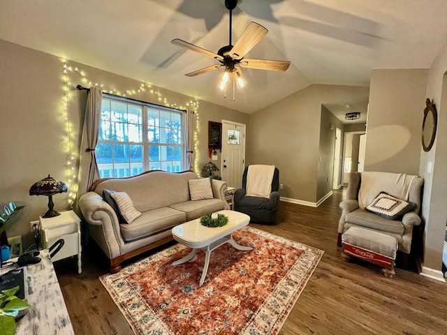 living room featuring ceiling fan, baseboards, vaulted ceiling, and wood finished floors