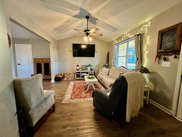 living area featuring lofted ceiling, ceiling fan, baseboards, and wood finished floors