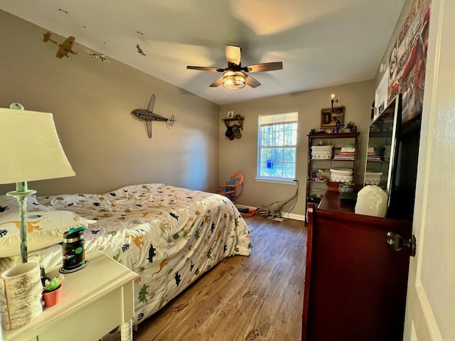 bedroom with ceiling fan, baseboards, and wood finished floors