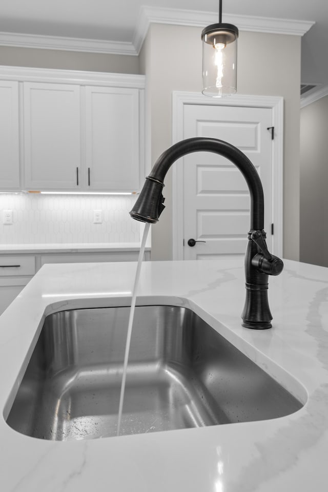 8904 Knolling Loop Unit 33, Ooltewah, TN 37363 - kitchen view of a sink, ornamental molding, white cabinetry, tasteful backsplash, and light stone countertops