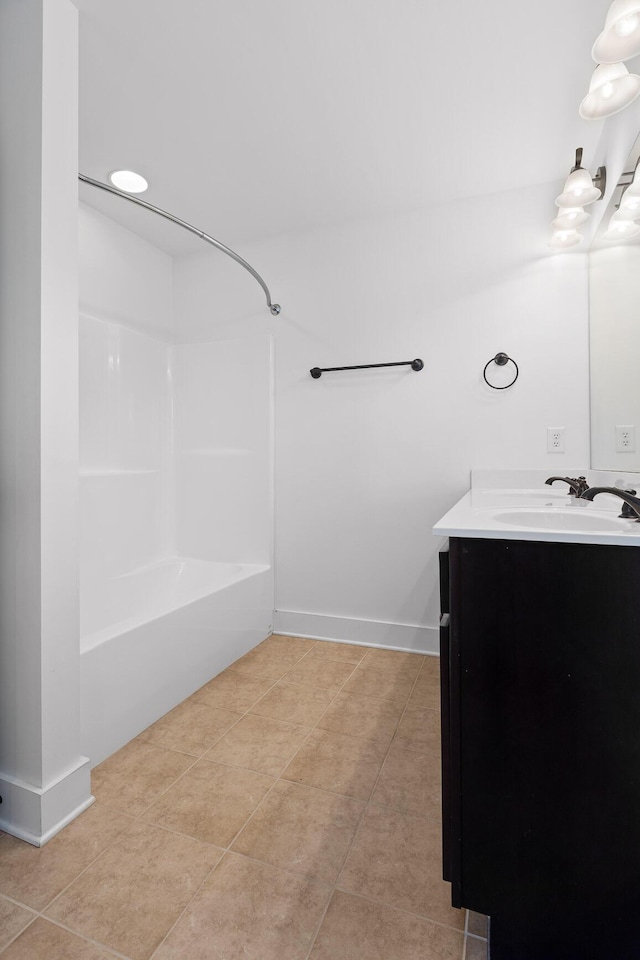 bathroom with tub / shower combination, vanity, baseboards, and tile patterned floors